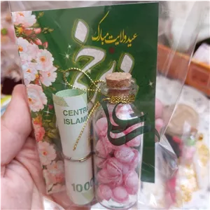 گیفت غدیرانه، شامل کارت تبریک عید غدیر، اسکناس رول شده با حلقه فلزی، شیشه شکلات با تزیین نامعلی  جنس پلکسی شیشه ای 